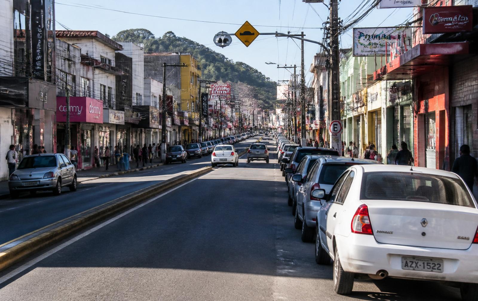 Rua comercial movimentada de Rio Branco do Sul ao entardecer